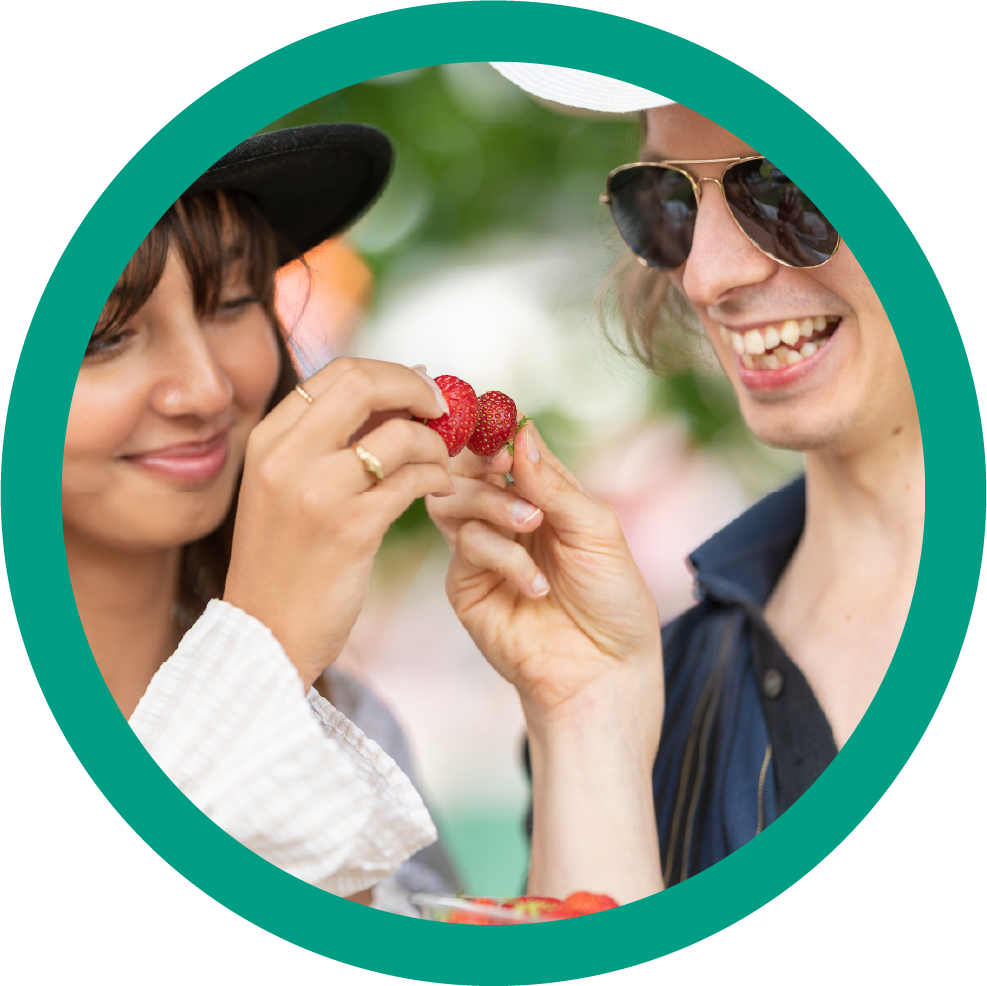 Two people doing cheers with strawberries